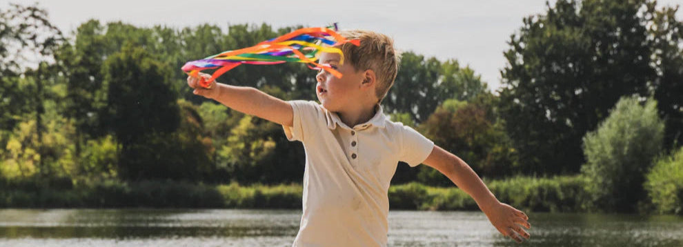 Jongen speelt met de wind en een handvlieger.
